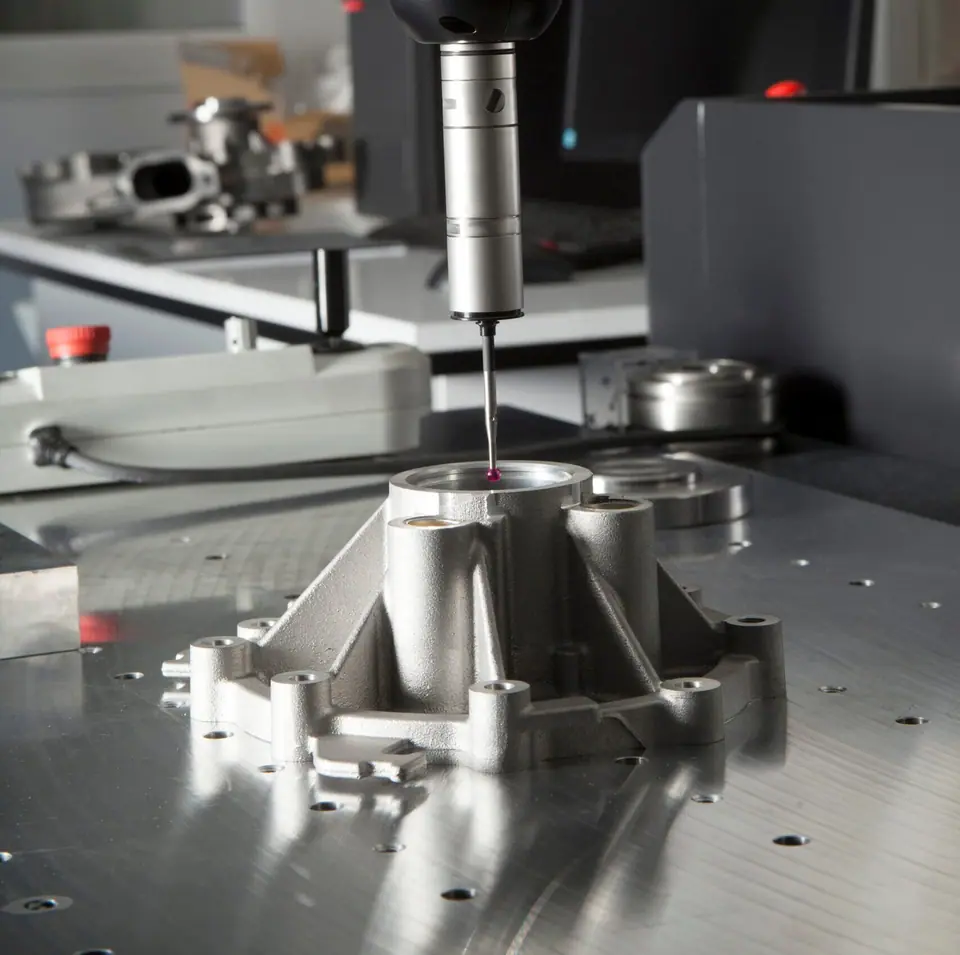 Coordinate measuring machine probing a cast aluminium part
